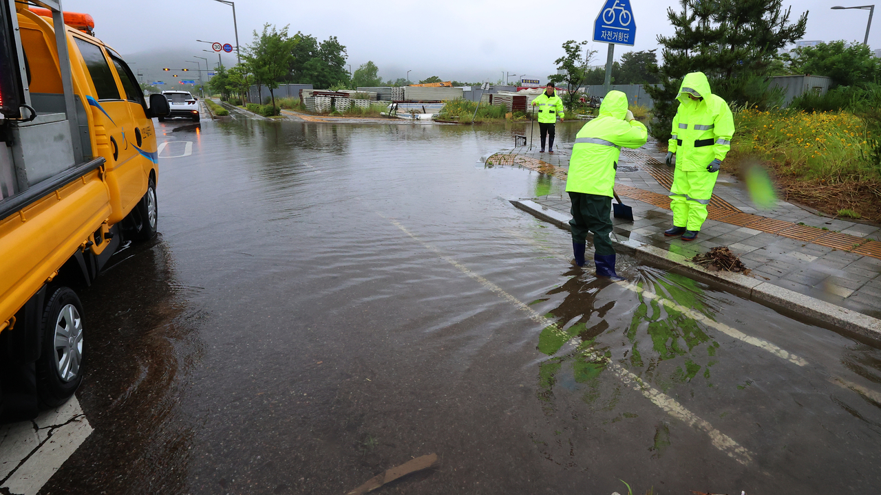 A road in Unnam-dong, Jung-gu, Incheon, was flooded due to heavy monsoon rains on Friday. (Yonhap)