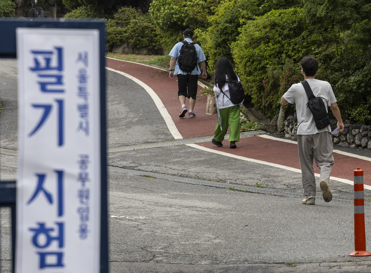 People walk toward testing areas to take the public servant exam at Kyungbock High School in central Seoul on Saturday. (Yonhap)