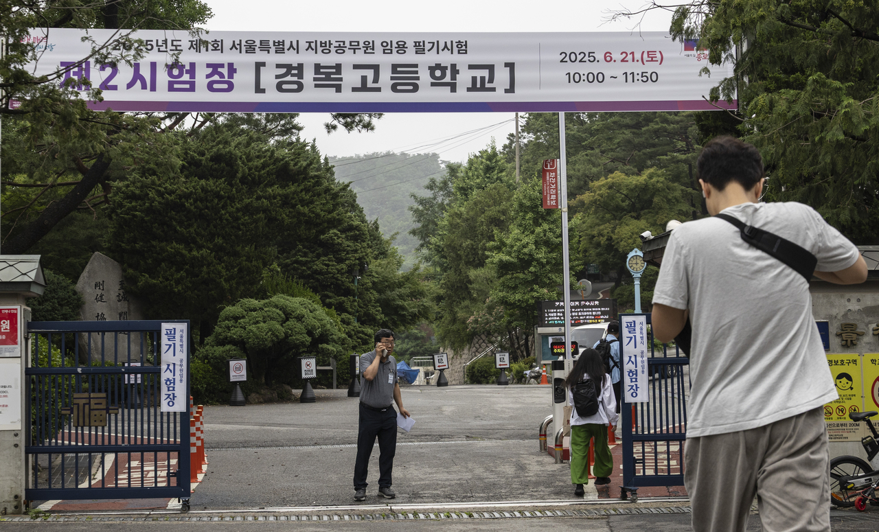 People walk toward testing areas to take the public servant exam at Kyungbock High School in central Seoul on Saturday. (Yonhap)