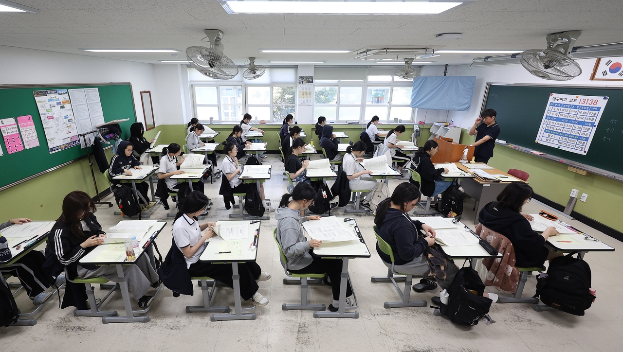 Students in their final year at Daegu Girls' High School look over distributed test booklets during the June 4 mock exam for South Korea's 2026 university entrance test. (Newsis)