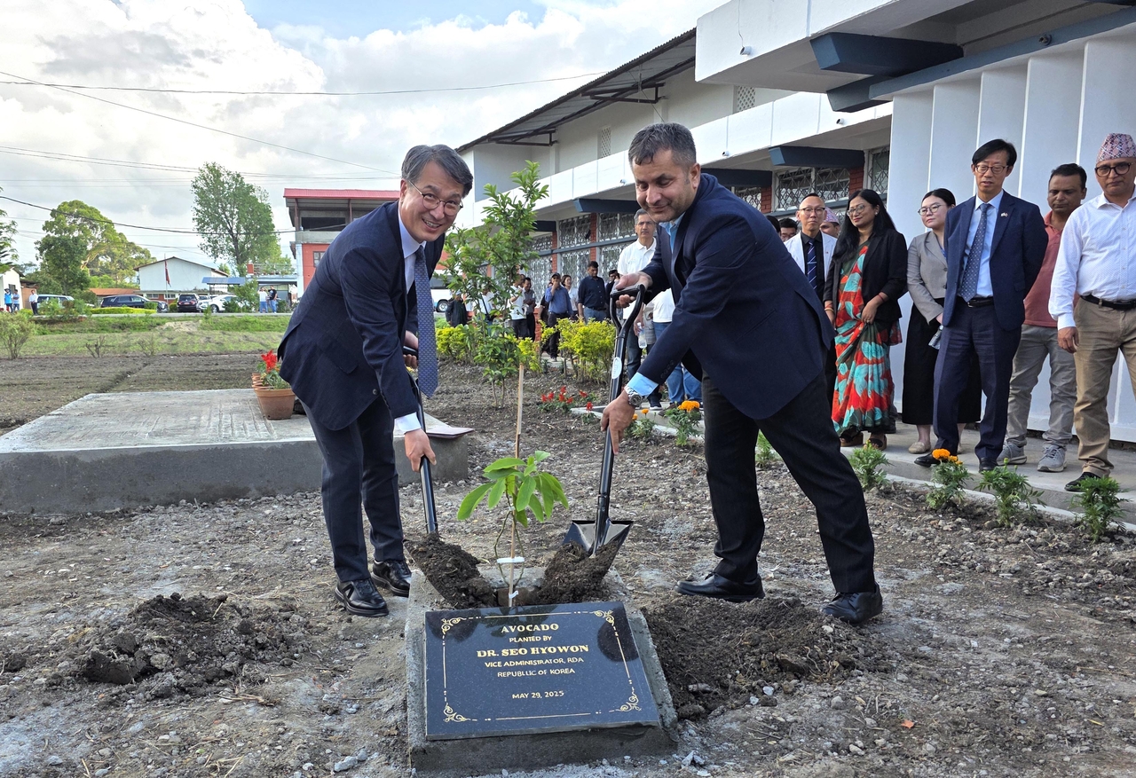 Deputy Administrator of the Rural Development Administration Seo Hyo-won (left) plants a commemorative tree with Govinda Prasad Sharma, secretary of Nepal’s Ministry of Agriculture and Livestock Development, during the opening ceremony of the KOPIA Nepal Center in Kathmandu on May 29. (RDA)
