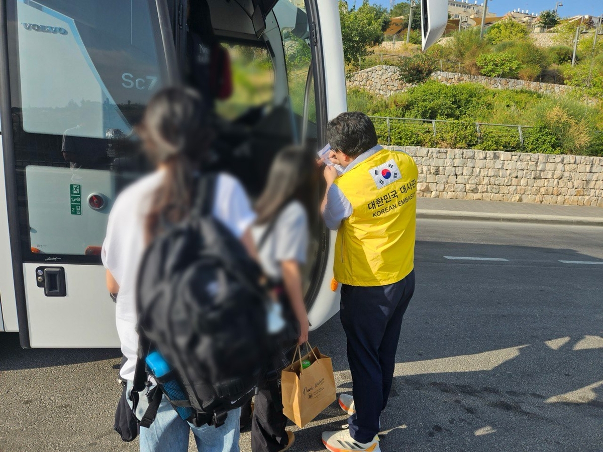 An official from the South Korean Embassy in Israel helps Korean nationals board a bus to a border area as part of an evacuation to Egypt amid the escalating conflict between Israel and Iran. (Ministry of Foreign Affairs)