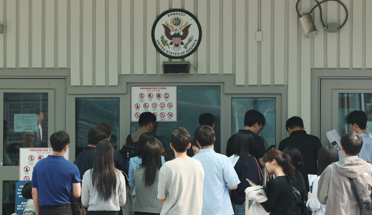 Individuals are seen lining up near the US Embassy in Jongno-gu, central Seoul, to file visa applications on May 28. (Yonhap)
