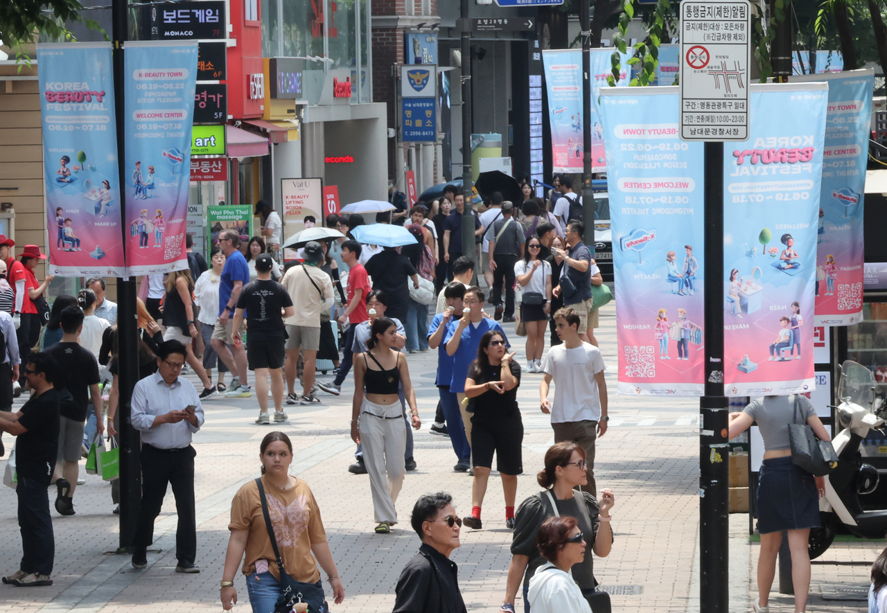 This photo shows people walking along a street in Myeong-dong, Seoul, Thursday. (Yonhap)