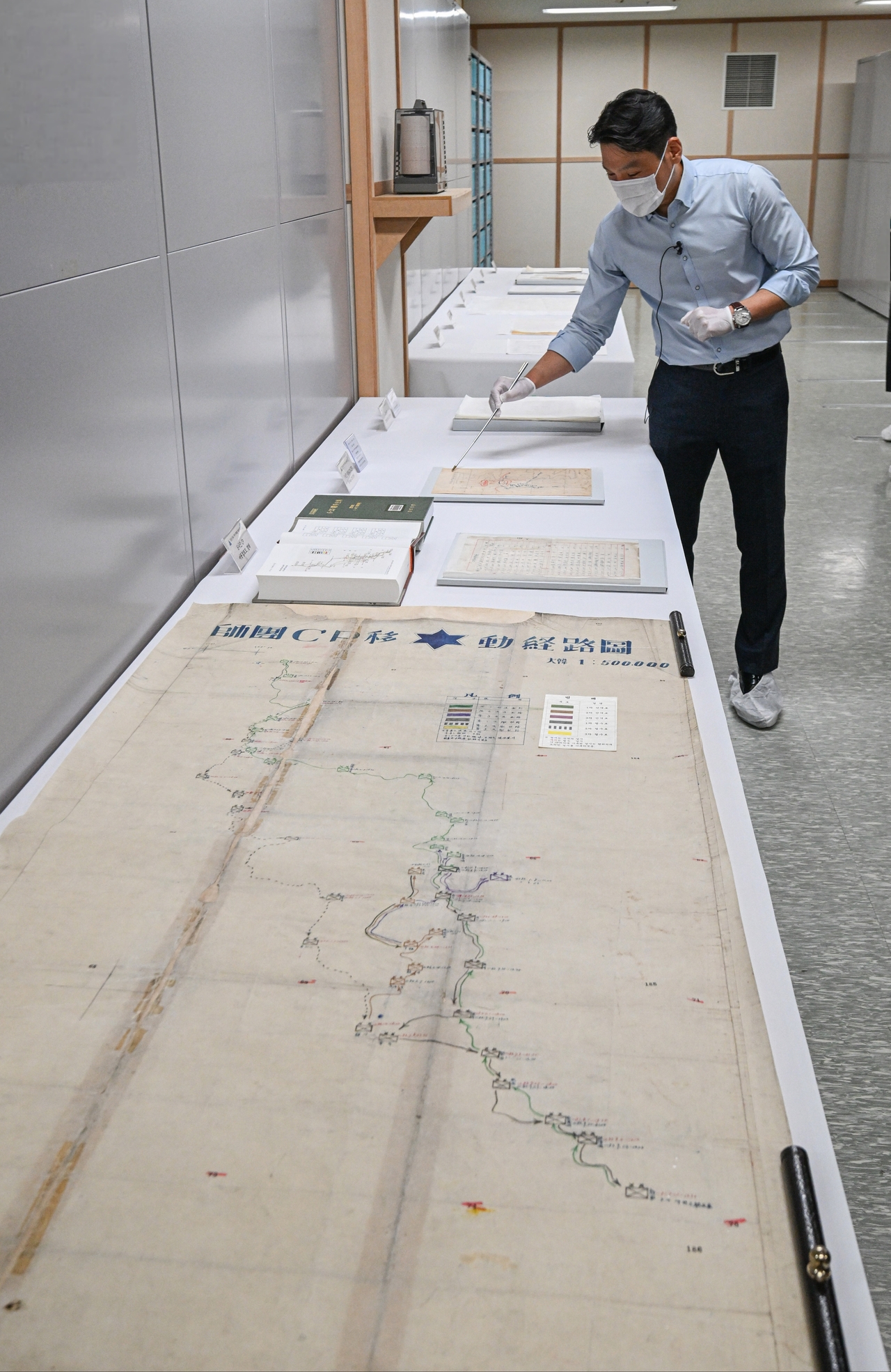 An official at the Army Archives Management Group, explains a 1.6-meter operational map tracing the 6th Division’s movements between 1950 and 1952 at the underground archive at Army headquarters in Gyeryong, South Chungcheong Province, Monday. (Republic of Korea Army)