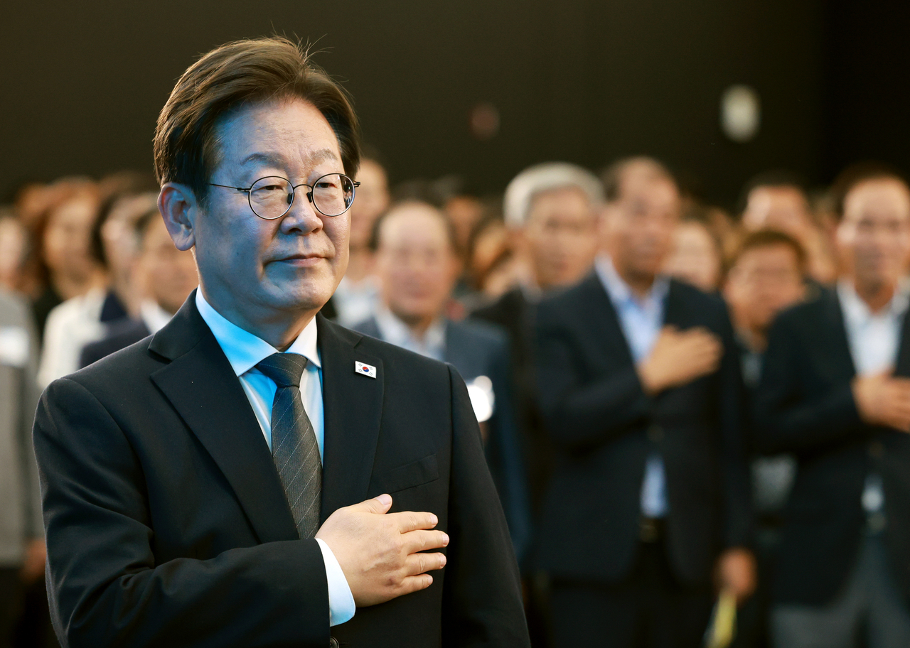 President Lee Jae Myung salutes the national flag during a meeting with citizens at the National Asian Culture Center in Gwangju on Wednesday. (Yonhap)