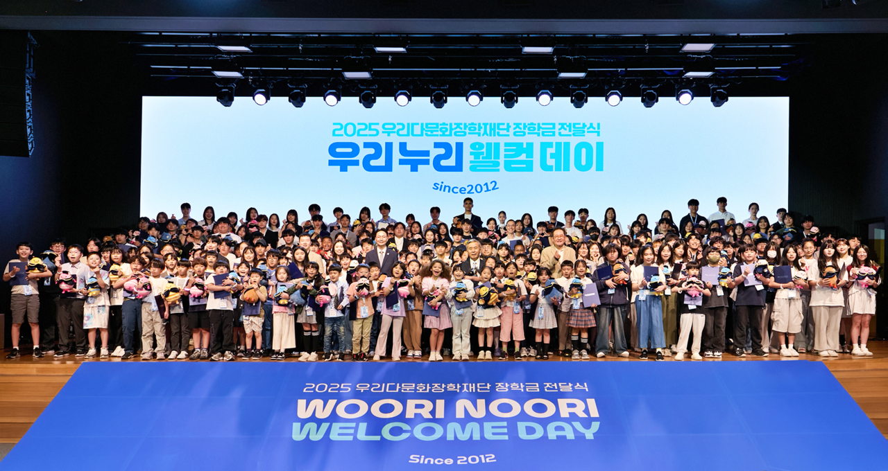 이종휘(가운데) 우리다문화장학재단 이사장과 김중곤(왼쪽) 굿네이버스 사무총장, 장광익(오른쪽) 우리다문화장학재단 사무국장이 지난 22일 서울 중구 소공로 우리은행 본점 비전홀에서 열린 장학금 전달식에서 레드벨벳 토토들과 기념촬영을 하고 있다. [우리금융 제공]