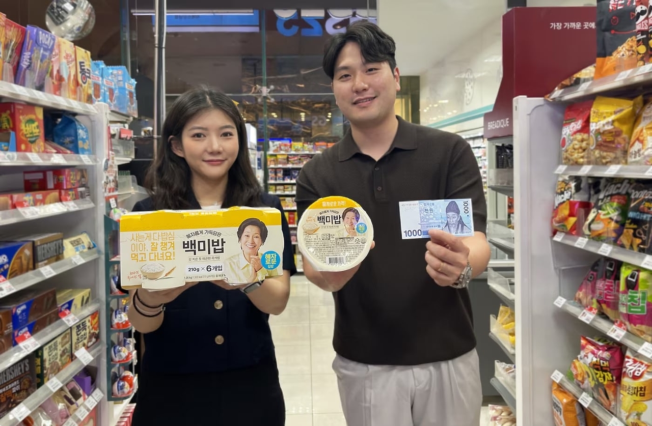 At a GS25 convenience store on June 3, staff showcase Hyeja Baekmibap, a new ultra-low-cost rice product priced at 1,000 won per pack. Despite the low price point, the 210-gram bowl ranks high in blind taste tests and is made from 100 percent Korean rice using optimized cooking methods, according to the company. (GS Retail)