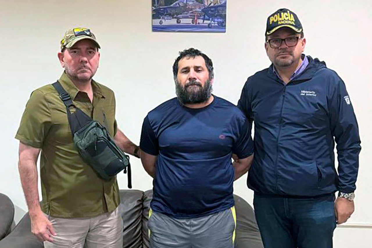 Adolfo Macias (center) is guarded after his recapture in Manta, Manabi Province, Ecuador, Wednesday. (AFP-Yonhap)
