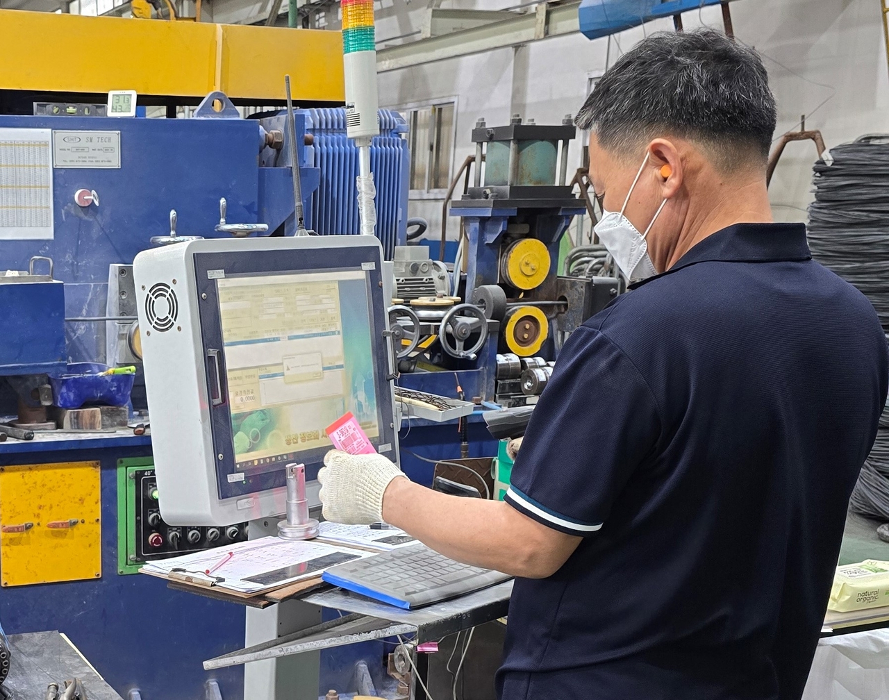An employee controls production equipment using a kiosk integrated with the manufacturing execution system. (Posco)