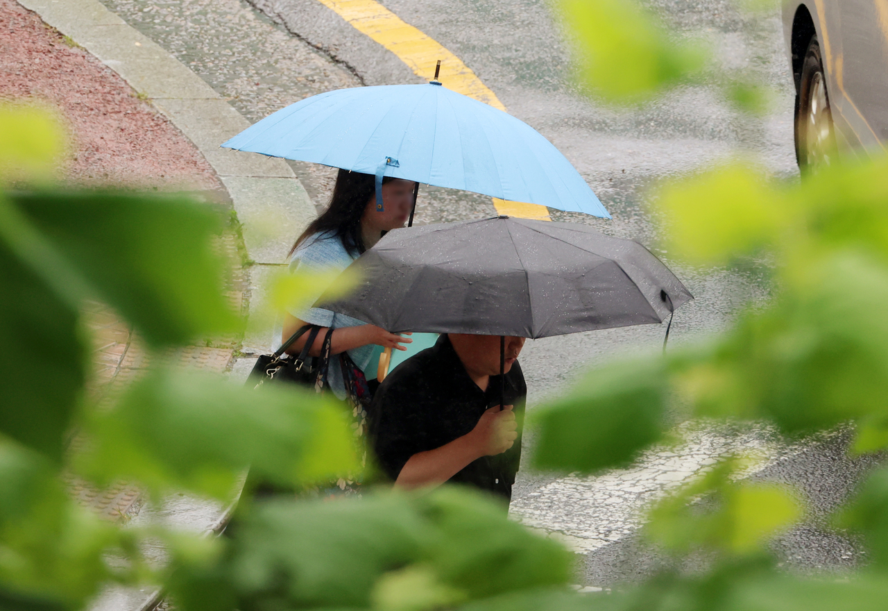 Pedestrians walk with umbrellas in Seo-gu, Gwangju, as the city was hit with heavy rain on Tuesday. (Yonhap)