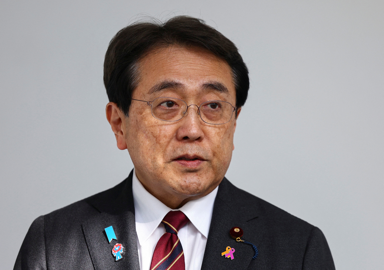 아카자와 료세이 일본 경제재생상이 지난 19일 하네다 공항에 도착한 후 취재진들에게 질의응답하는 모습. [로이터]