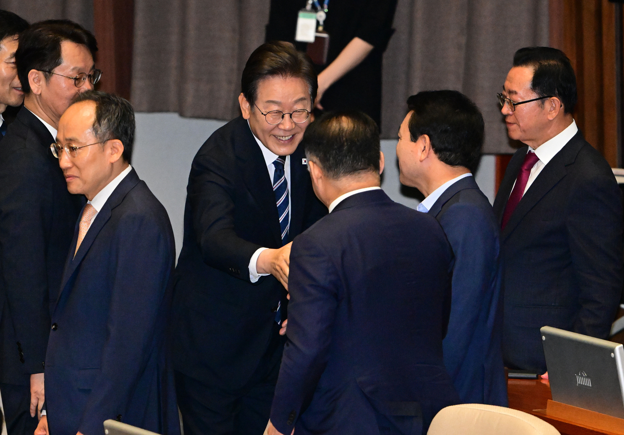 President Lee Jae Myung (third from left) shakes hands with lawmakers following his speech to the National Assembly on Thursday. Lee Sang-sub/The Korea Herald