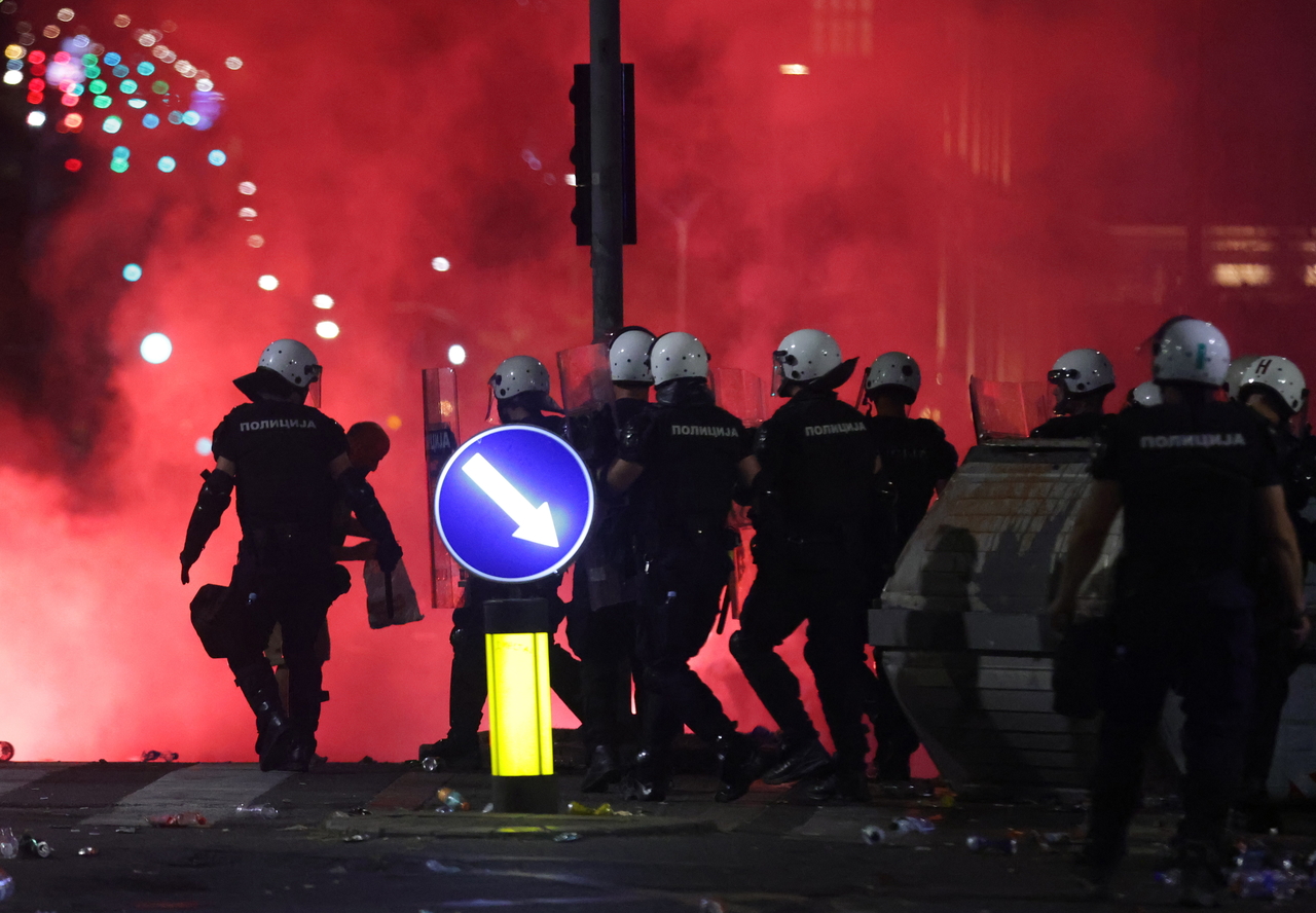 Protestors throw projectiles at riot police officers in Belgrade, Serbia, Saturday. (EPA-Yonhap)