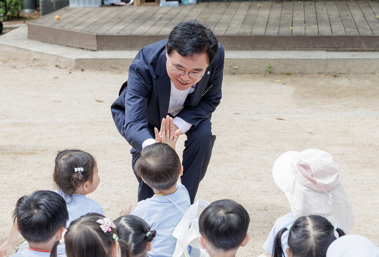 진교훈 강서토토사이트 라이브이 플리마켓에 참여한 어린이와 손을 맞대고 있다. [강서구 제공]