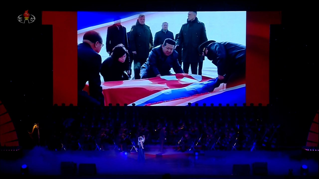 North Korea’s state-run Korean Central Television on Monday released footage of North Korean performers on stage in front of a screen showing leader Kim Jong-un receiving the remains of fallen North Korean soldiers repatriated from Russia, during a performance at the East Pyongyang Grand Theatre on Sunday, attended by Russian Culture Minister Olga Lyubimova. (Yonhap)