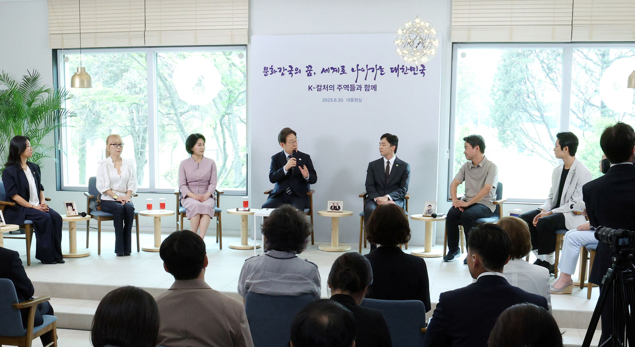 President Lee Jae Myung (fourth from left) talks during  a meeting with the country's cultural figures held at the Presidential Office in Yongsan on Monday.  (Yonhap)