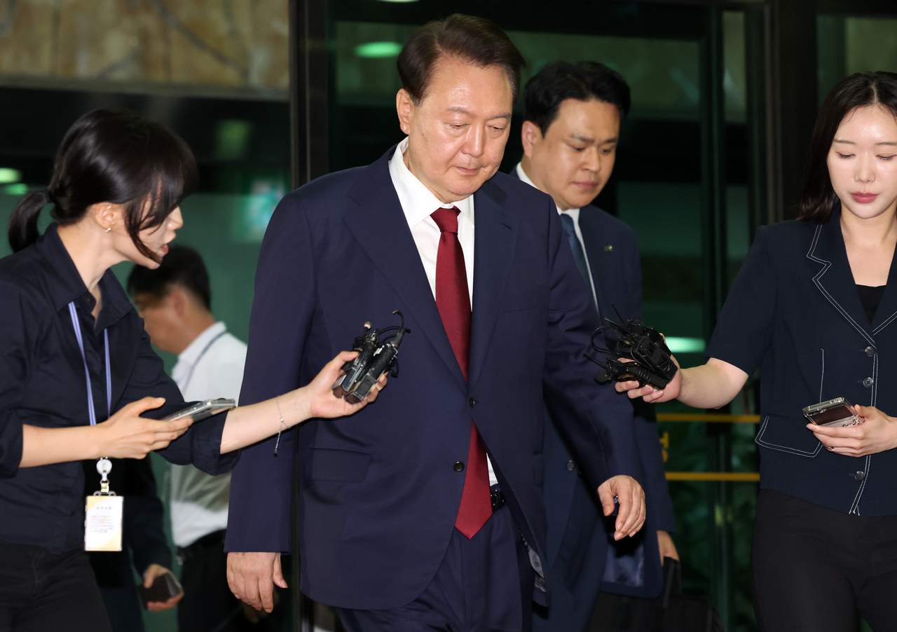 Former President Yoon Suk Yeol (center) leaves the Seoul High Prosecutors Office in southern Seoul on Monday, after undergoing questioning by a special counsel team. (Yonhap)