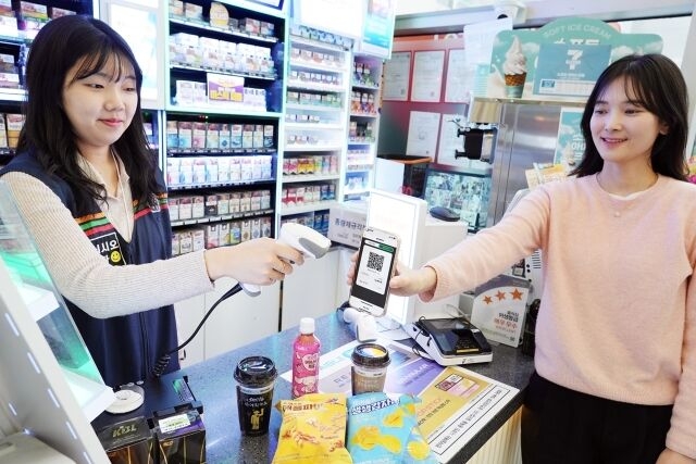 A customer demonstrates how to use a central bank digital currency to purchase items at a local convenience store. (7-Eleven)