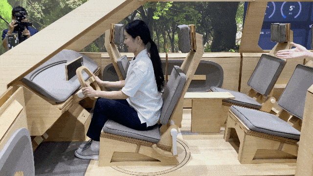 A UX Studio Seoul staff member demonstrates how in-car elements can be adjusted on a wooden prototype during a media preview on Tuesday in southern Seoul. (Lim Jae-seong/The Korea Herald)