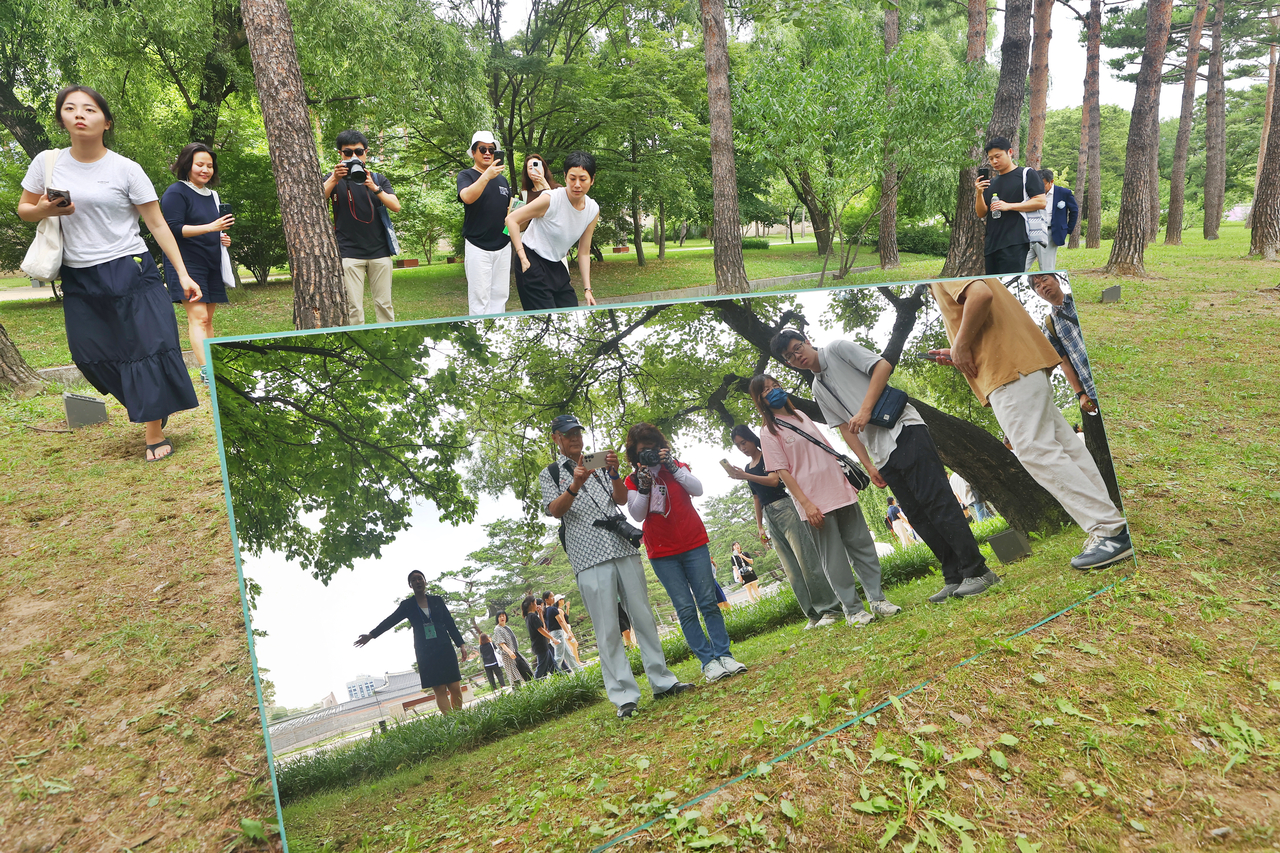 Visitors look at an installment on display at Gyeonghoeru, a two-story pavilion structure at Gyeongbokgung, in Seoul, Wednesday. (Yonhap)