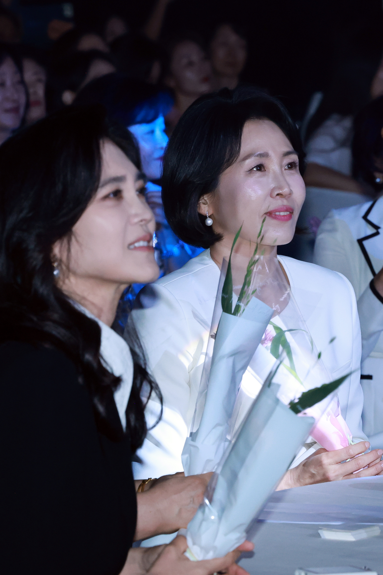 이재명 대통령의 배우자 김혜경 여사가 1일 서울 중구 신라호텔 다이너스티홀에서 열린 제4회 여성골드문 토토사이트 추천주간 개막식에 참석해 어린이 합창단원에게 받은 꽃을 들고 축하 공연을 보고 있다. 왼쪽은 이부진 호텔신라 사장. [연합]