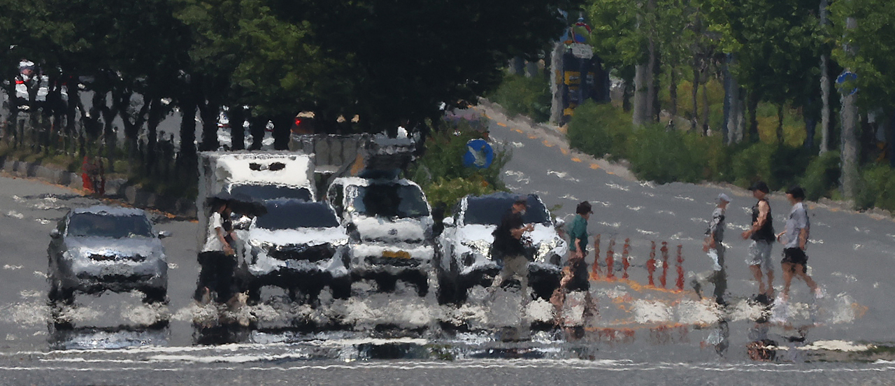 Pedestrians walk across the street in Daegu on Thursday. (Yonhap)