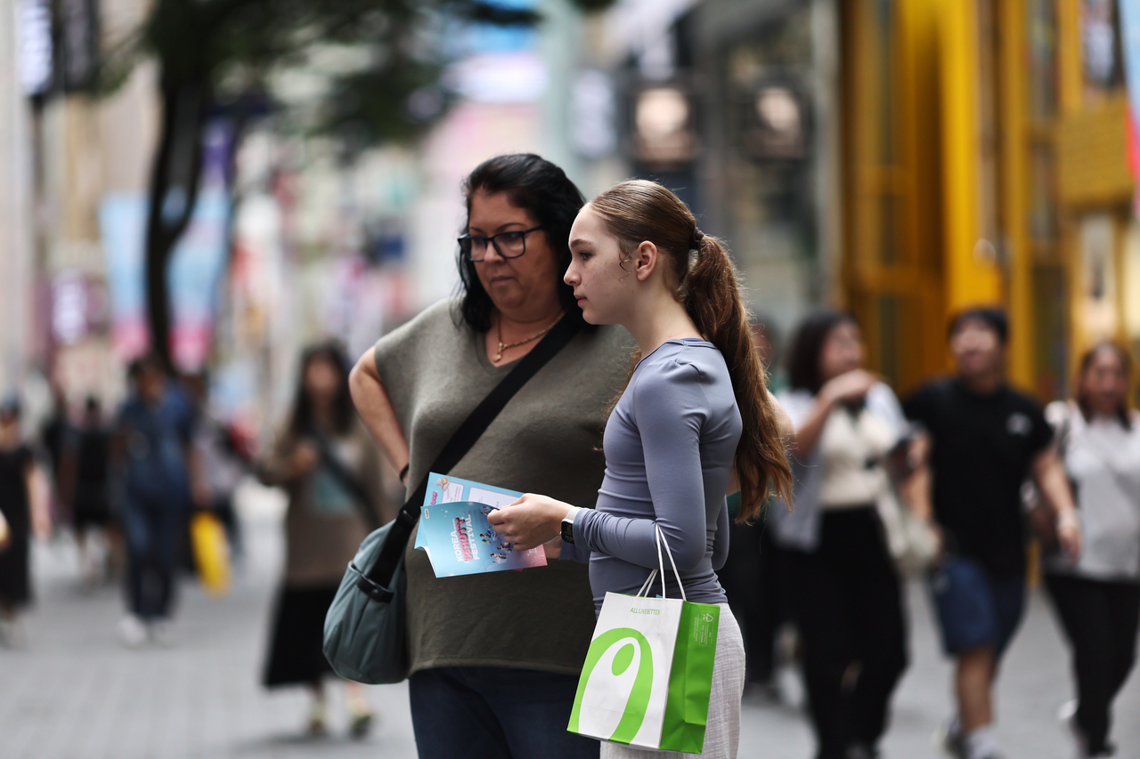 Two pedestrians walk the street of Myeongdong in Jung-gu, Seoul, June 26. (Yonhap)