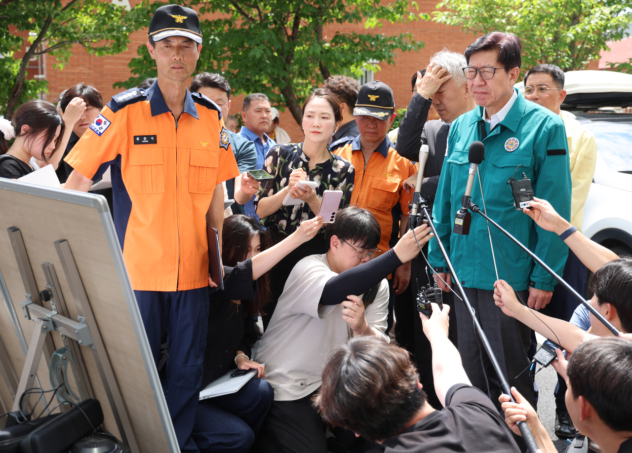 Busan Mayor Park Hyung-joon (right) visits the site of the deadly apartment fire that killed two girls in Busan's Gijang district on Thursday. (Yonhap)