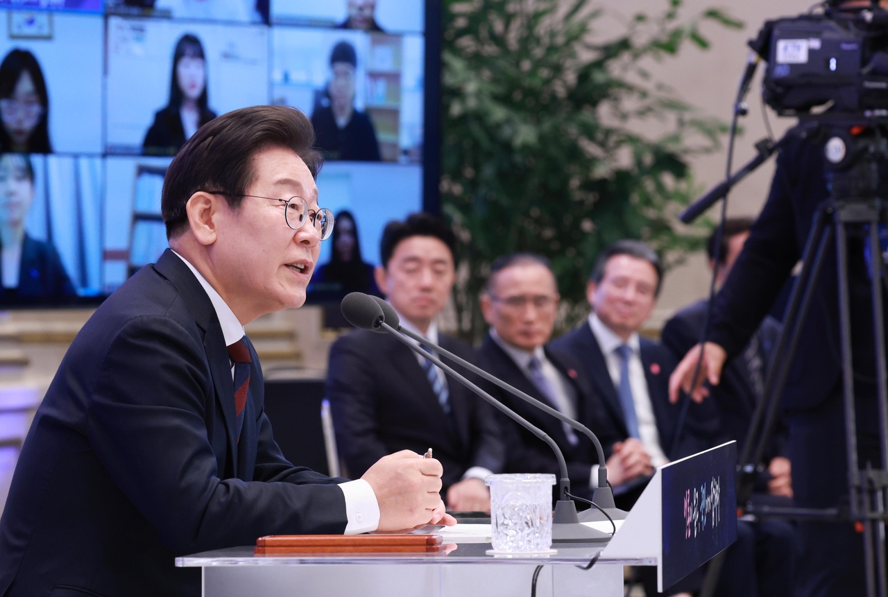 President Lee Jae Myung (left) and his aides attend a news conference held at Cheong Wa Dae in Seoul on Thursday. (Pool photo via Yonhap)