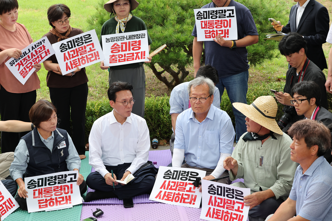 Prime Minister Kim Min-seok, second from left, listens to groups of farmers protesting against President Lee Jae Myung’s decision to reappoint Agricultural Minister Song Mi-ryung, at a rally held across the presidential office in Yongsan-gu, Seoul on Friday. Yonhap
