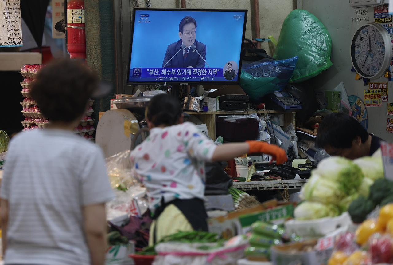 Merchants at Inwang Market in Seodaemun-gu watch a live broadcast on July 3 as President Lee Jae Myung holds a press conference marking his first 30 days in office. (Yonhap)