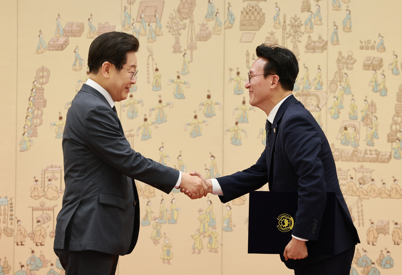 President Lee Jae Myung (left) shakes hands with Prime Minister Kim Min-seok after presenting him with a certificate of appointment during a ceremony held at the presidential office in Seoul on Friday. (Yonhap)