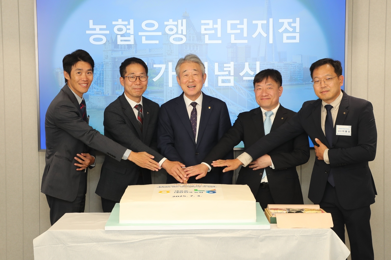 National Agricultural Cooperative Federation Chair Kang Ho-dong (center) poses for a picture with employees at a Nonghyup Bank branch in London on Thursday. (National Agricultural Cooperative Federation)