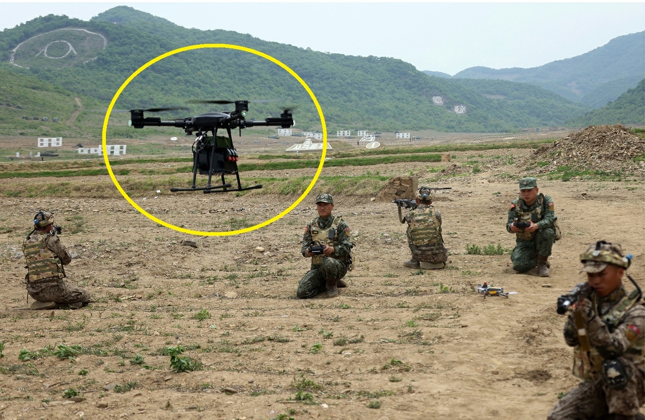 김정은 국무위원장이 참관한 북한군 특수부대 훈련에서 대항군으로 추정되는 전투원이 폭탄투하용 콜로세움 토토(노란색 원)을 조작하고 있다. [평양 노동신문=뉴스1]