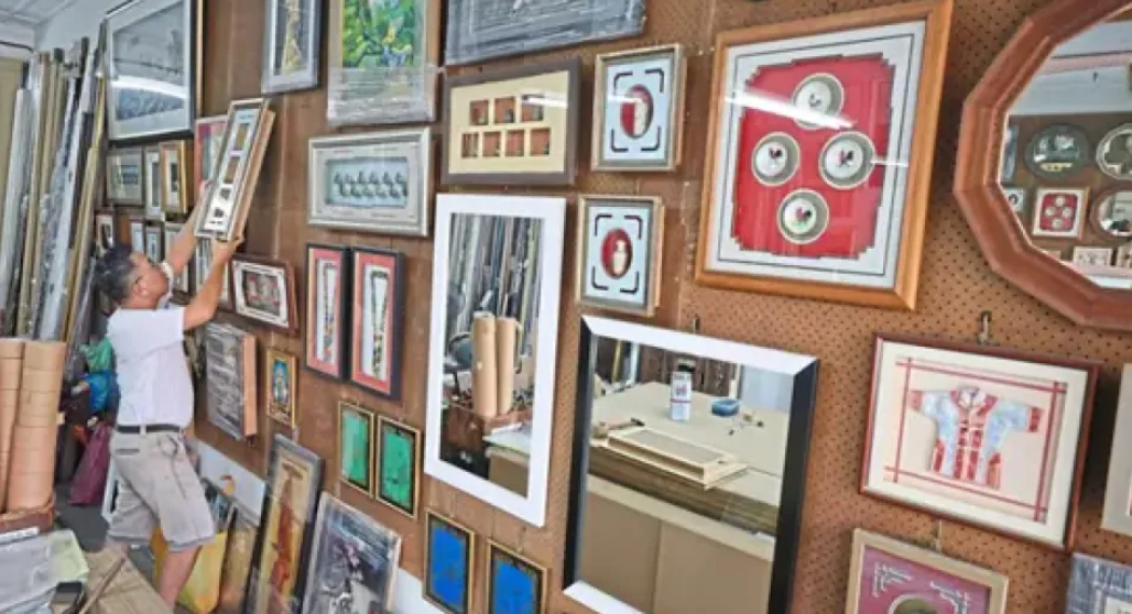 Ng Boon Hooi showing the 3D frames he has made for customers at his shop along Chulia Street in George Town.    (The Star)