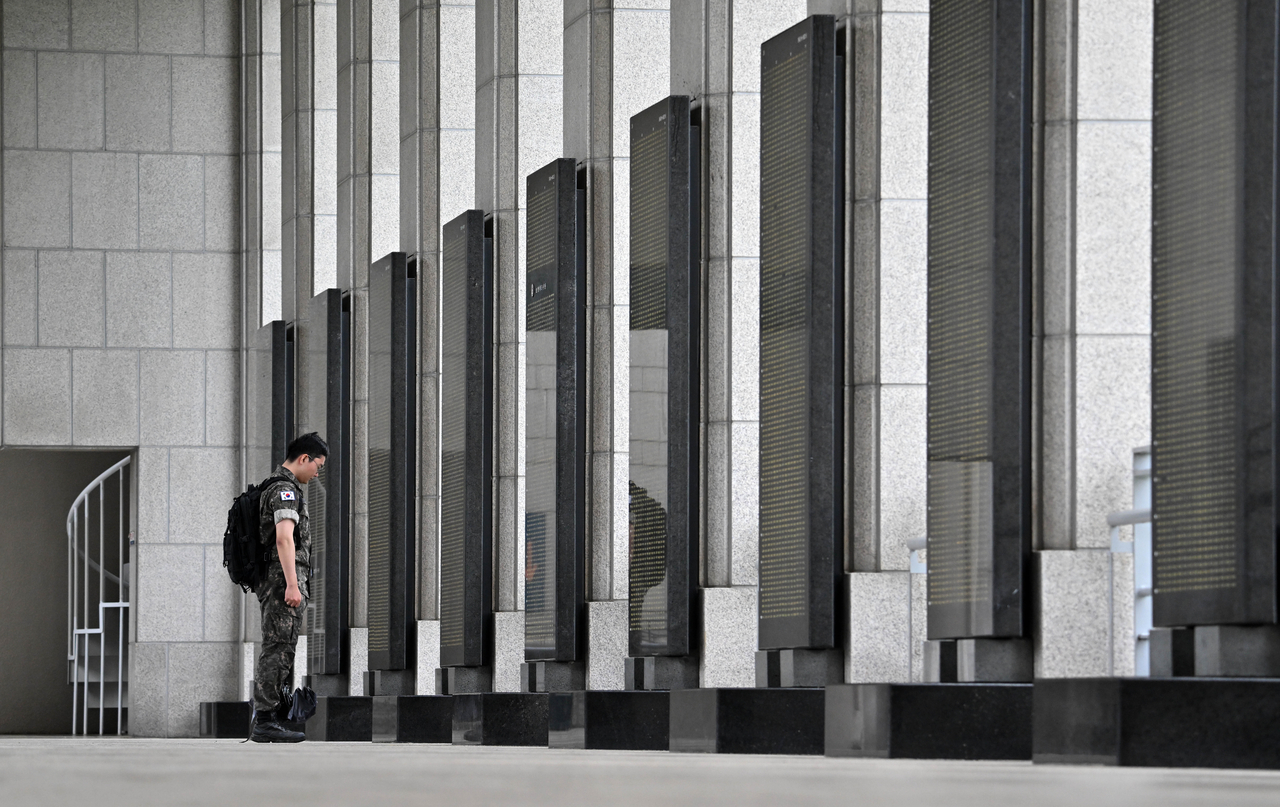 A South Korean soldier pays tribute to the fallen in front of the list of war dead at the War Memorial of Korea in Yongsan-gu, Seoul, Wednesday, as the nation marks the 75th anniversary of the start of the Korean War.  (Im Se-jun/The Korea Herald)