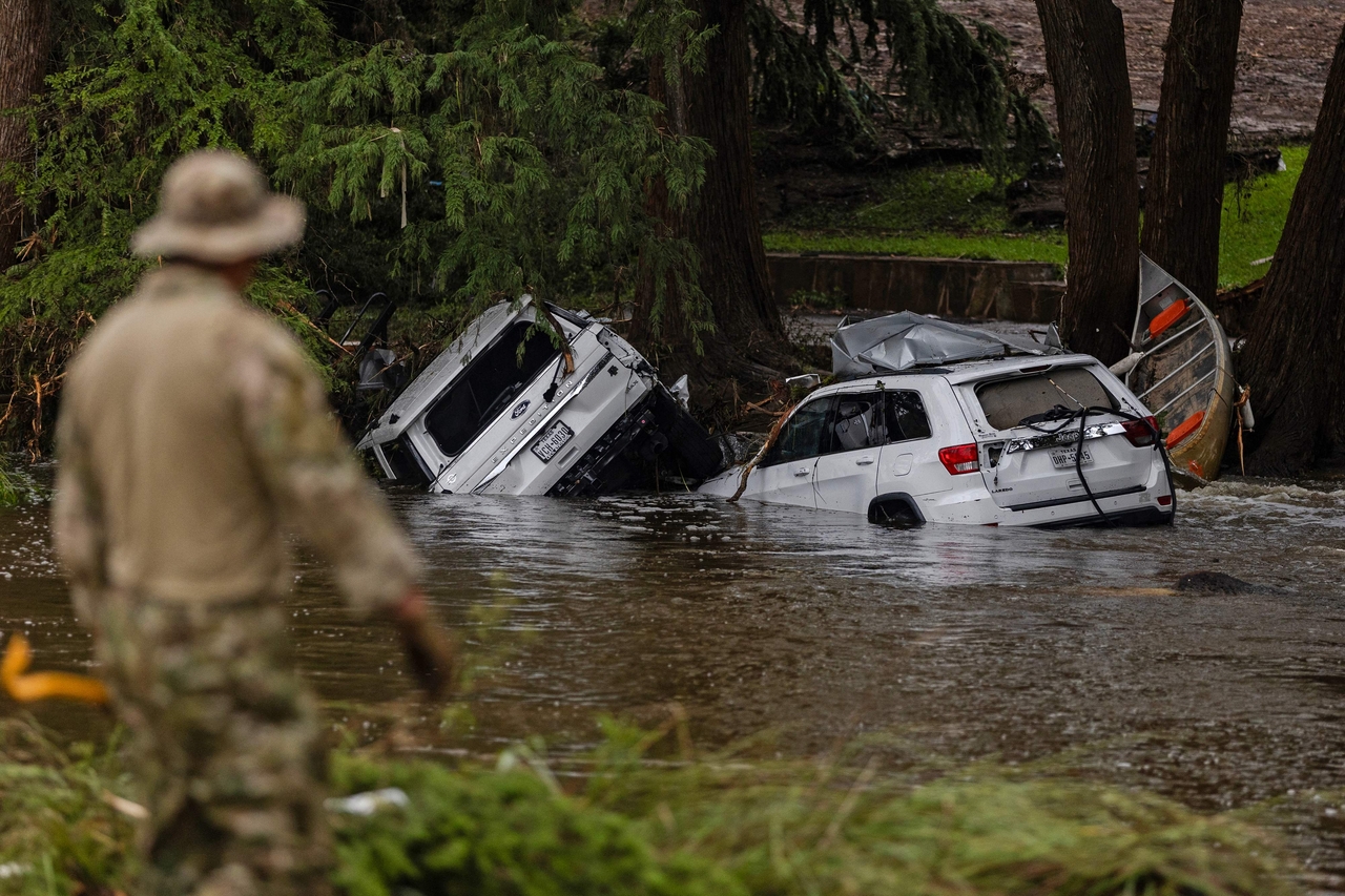 Vehicles sit submerged as a search and rescue worker looks through debris for any survivors or remains of people swept up in the flash flooding in Hunt, Texas, Sunday.   AFP-Yonhap