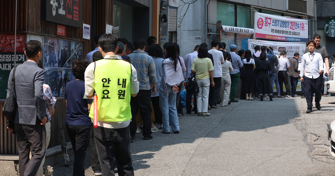 Voters line up outside the Sogong-dong Community Service Center in Jung-gu, Seoul, on Thursday, the first day of the two-day early voting period for the June 3 presidential election. (Yonhap)