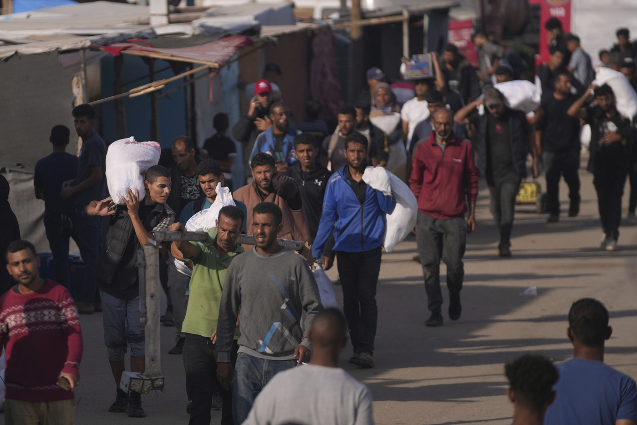 Palestinians carry bags containing food and humanitarian aid packages delivered by the Gaza Humanitarian Foundation, a US-backed organization approved by Israel, in Khan Younis, Gaza Strip, Sunday. (AP-Yonhap)