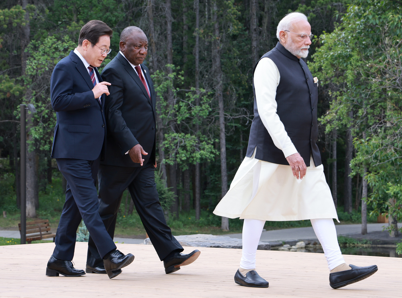 President Lee walks with South African President Cyril Ramaphosa for a group photo session during the G7 meeting in Canada on Tuesday. (Yonhap)