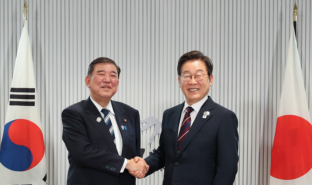 President Lee (right) and Japanese Prime Minister Shigeru Ishiba shake hands during their bilateral meeting held on the margins of the Group of Seven summit in Canada on Tuesday. (Yonhap)