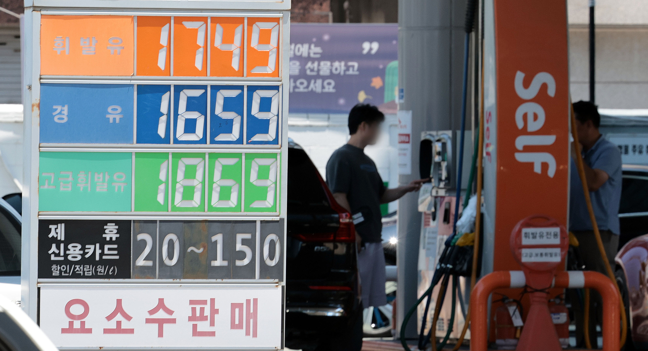 A consumer refuels at a self-service gas station in Seoul on Sunday. (Yonhap)