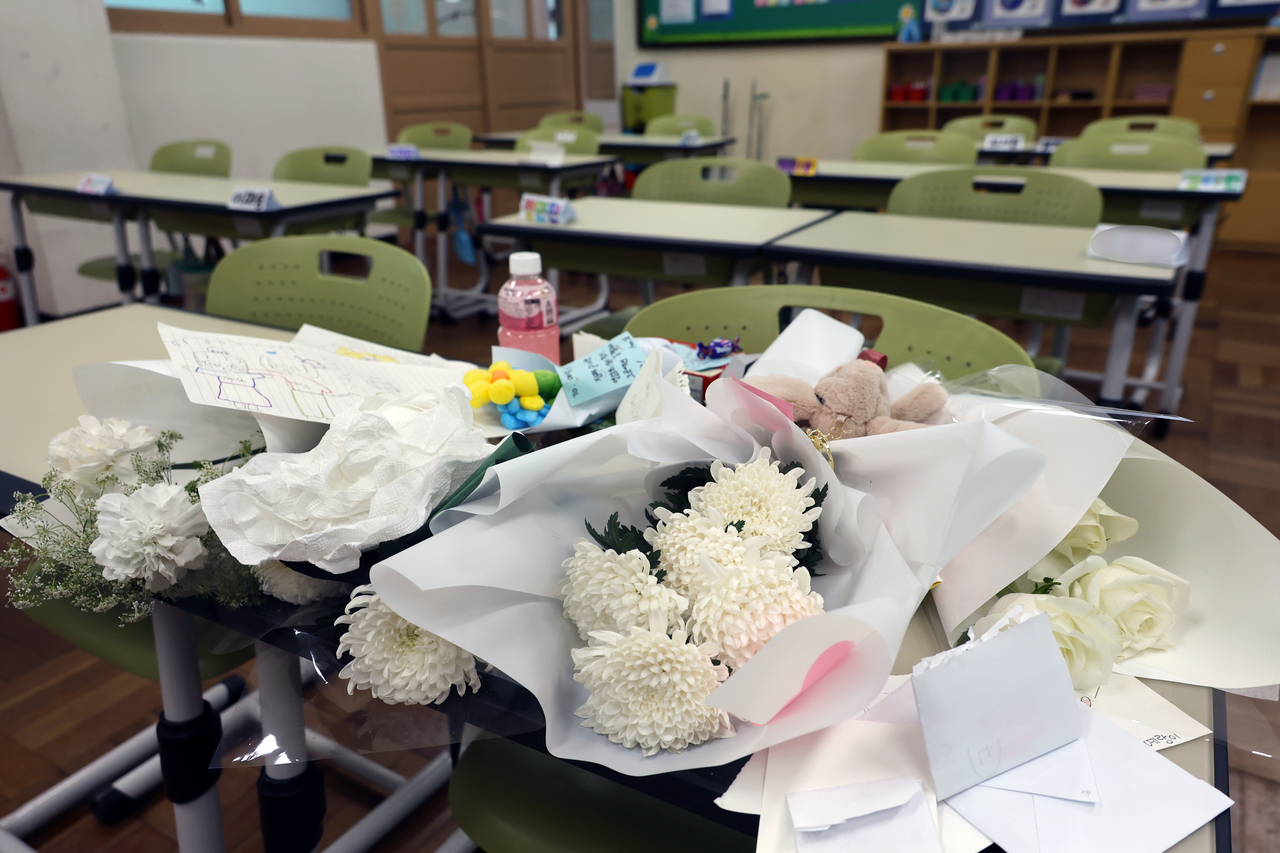 Flowers and letters from classmates are placed on the desk of a 10-year-old girl who died in an apartment fire, at an elementary school in Busanjin District, Busan, Wednesday. (Yonhap)