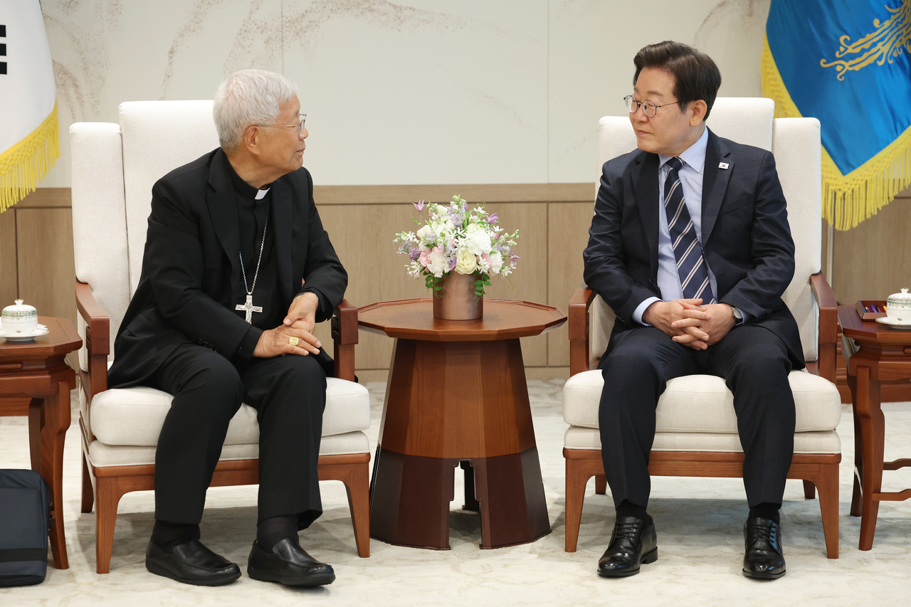 President Lee Jae Myung (right) hold talks with Cardinal Lazarus You Heung-sik at the presidential office in Seoul on Monday. (Yonhap)