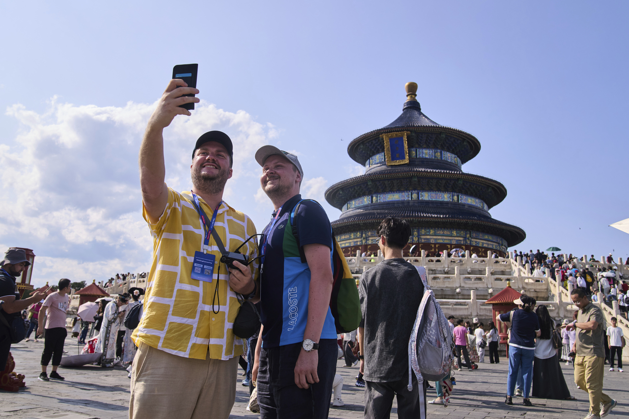 Tourists take a selfie at the Temple of Heaven as they take a half-day tour offering by a travel agency in Beijing on June 15.   AP-Yonhap