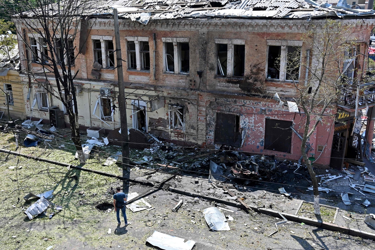 A man stands among debris next to a building damaged after a drone attack in Kharkiv, Ukraine, Monday. (AFP-Yonhap)