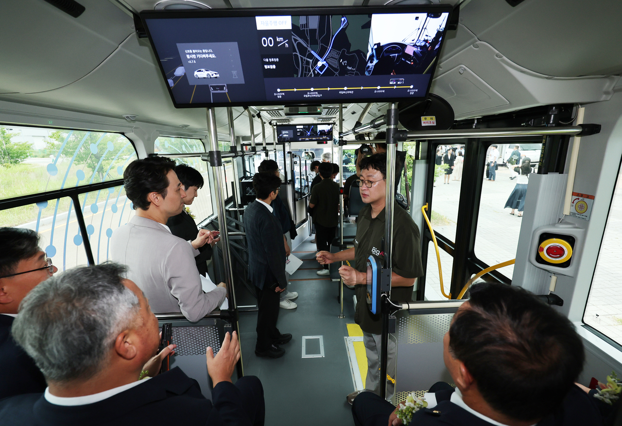 Busan city officials and invited guests, including members of the media, ride the self-driving bus in Busan during its test-run Thursday. (Yonhap)