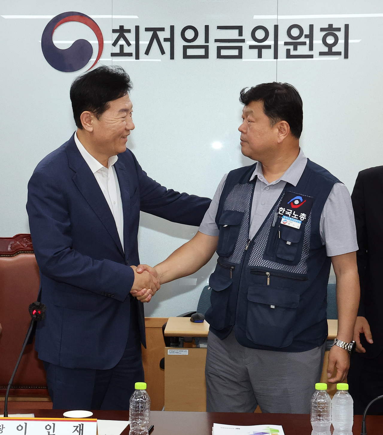 The Korea Enterprises Federation's executive director Ryu Gi-jeong (left) shakes hands with Ryu Ki-seob, secretary general of the Federation of Korean Trade Unions, after reaching an agreement in a meeting held at the government complex in Sejong on Thursday. (Yonhap)