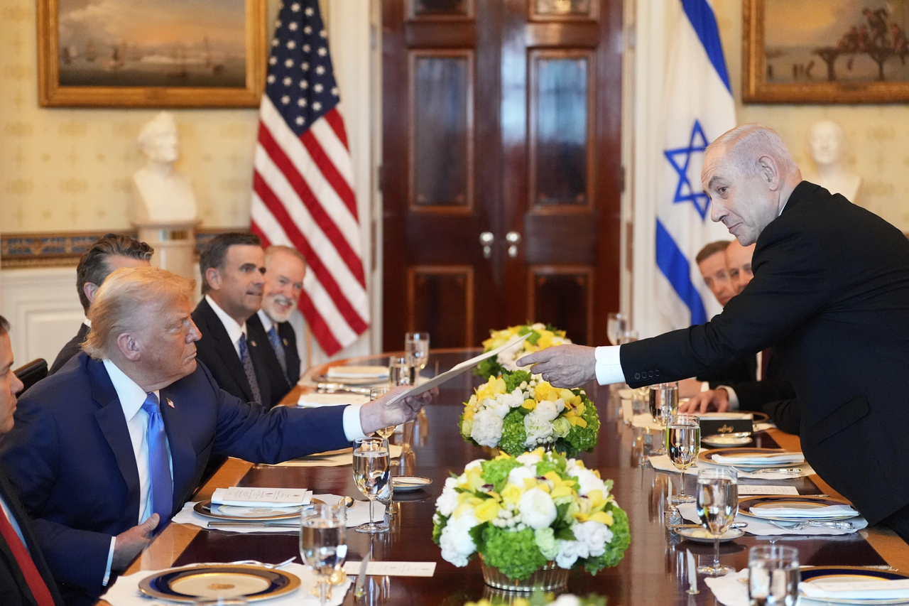 Israel’s Prime Minister Benjamin Netanyahu (right) hands President Donald Trump a folder during a meeting in the Blue Room of the White House, Monday, in Washington. (AP)
